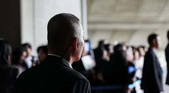 A security officer facing a crowd at an event