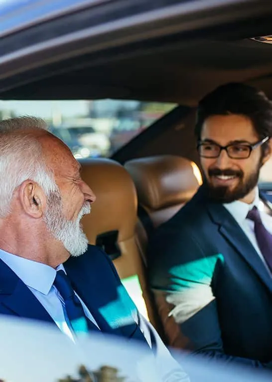 Two men talking in the back seat of a car