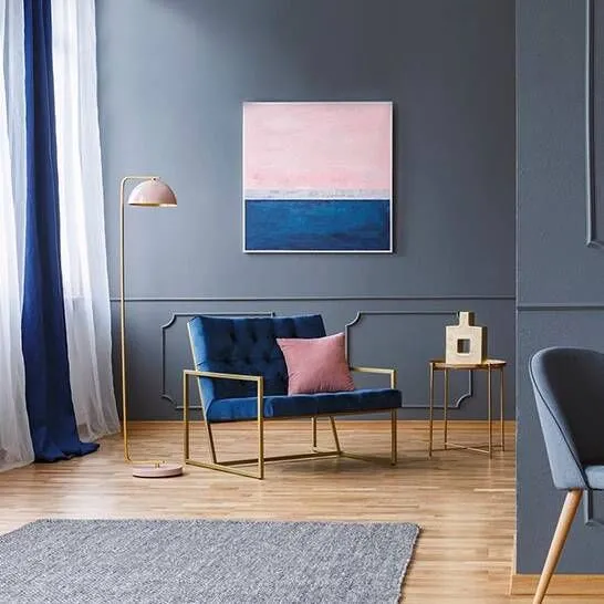 A drawing room with a velvet armchair and artwork